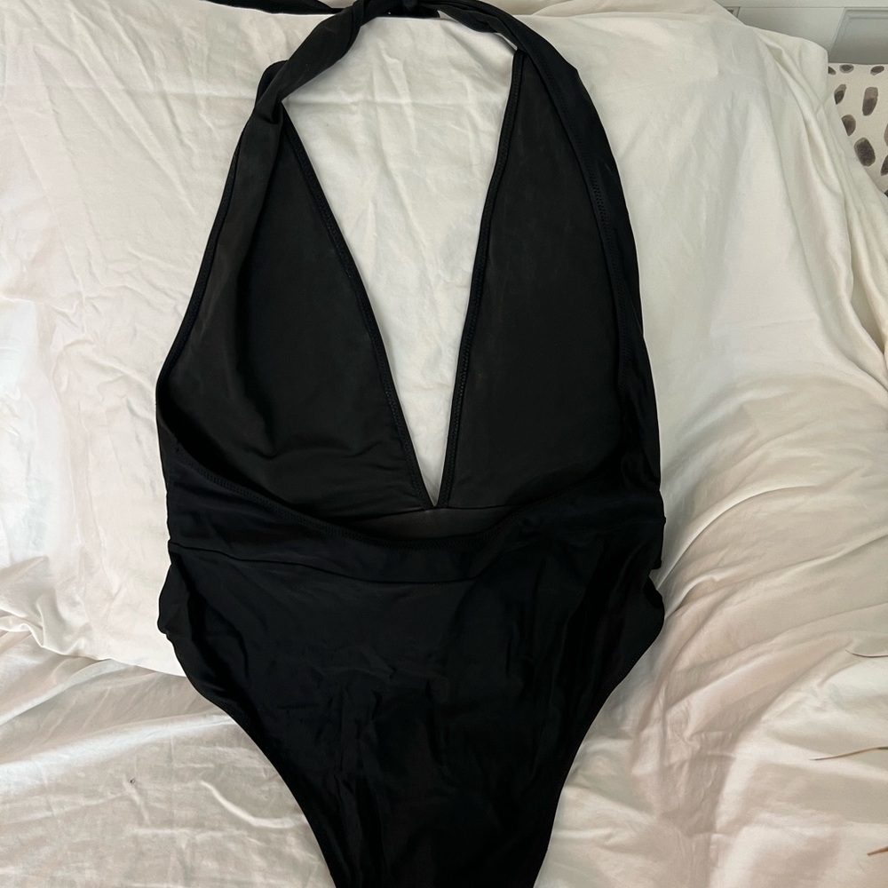 Black one piece bathing suit. Deep V plunge with attached belt.
